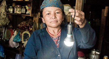 woman holding light solar power Nepal earthquake