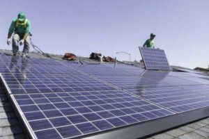 Workers install solar panels