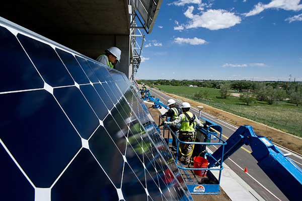 Installers attach photovoltaics to the south face of the NREL parking garage