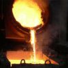Pouring a ladle of molten silicon into casting area.