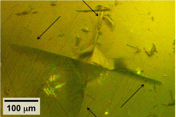 Using specialized equipment, the MIT team did tests in which they used a pyramidal-tipped probe to indent the surface of a piece of the sulfide-based material. Surrounding the resulting indentation (seen at center), cracks were seen forming in the material (indicated by arrows), revealing details of its mechanical properties. Courtesy of the researchers