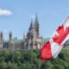 Canadian-flag-waiving-with-Parliament-buildings-in-background