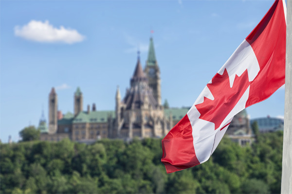 Canadian-flag-waiving-with-Parliament-buildings-in-background