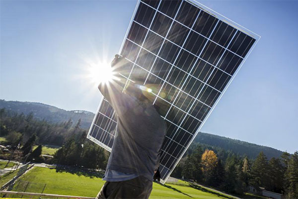 man-holding-solar-panels-sun